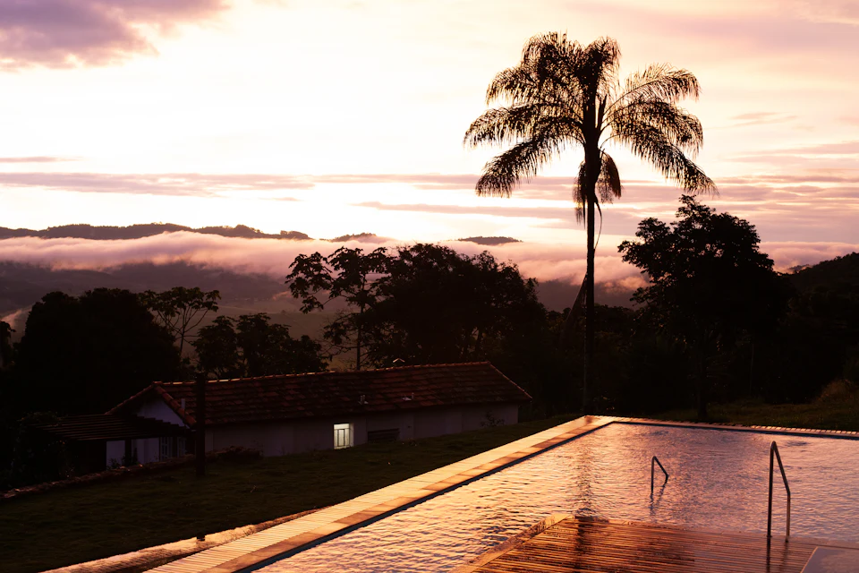 Piscina exterior ao pôr do sol com vista para o campo